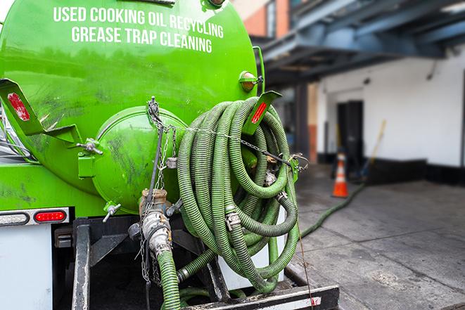 a grease trap being pumped by a sanitation technician in Addison